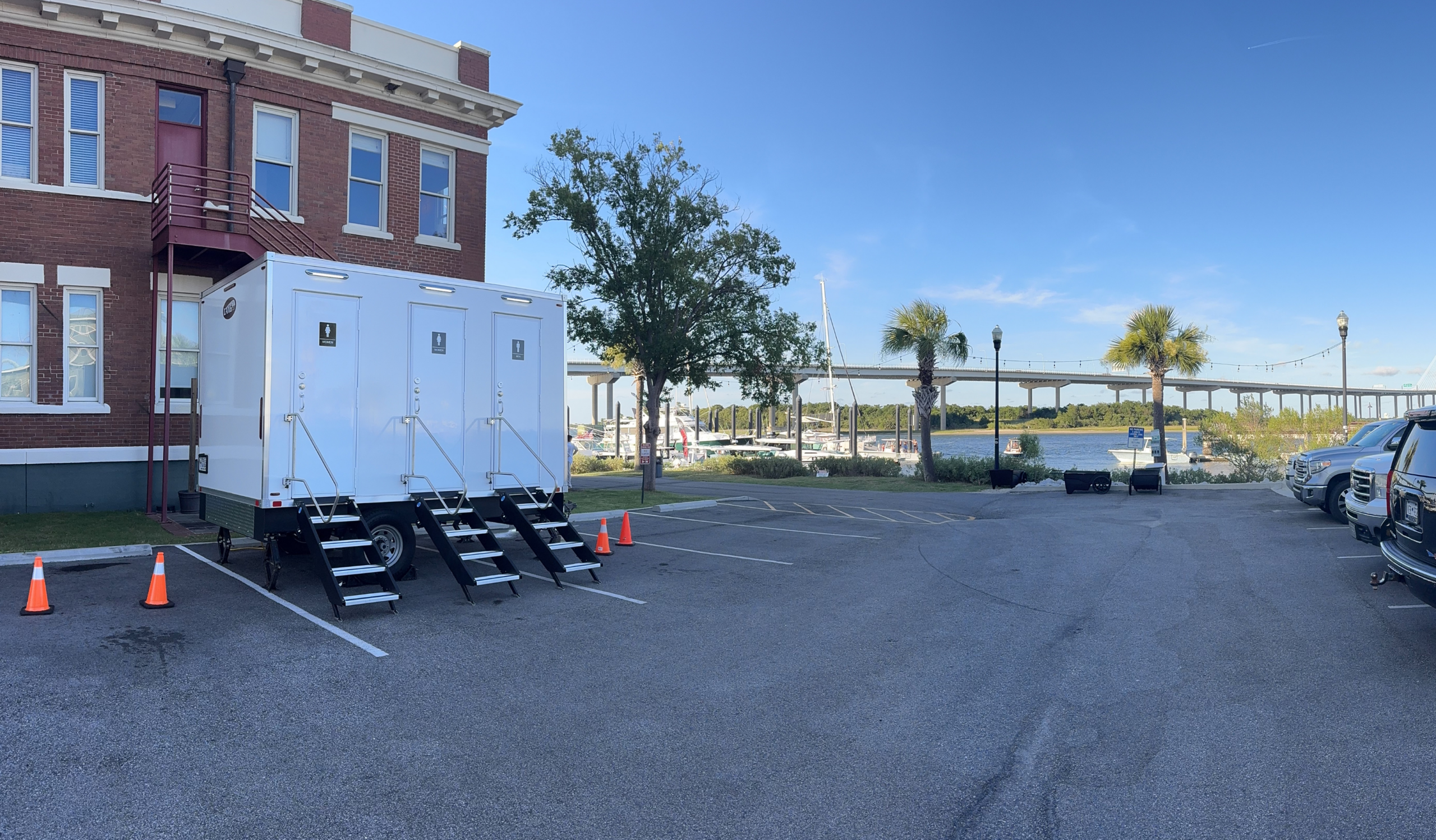 Restroom trailer with three private stalls set up at a downtown Charleston marina event